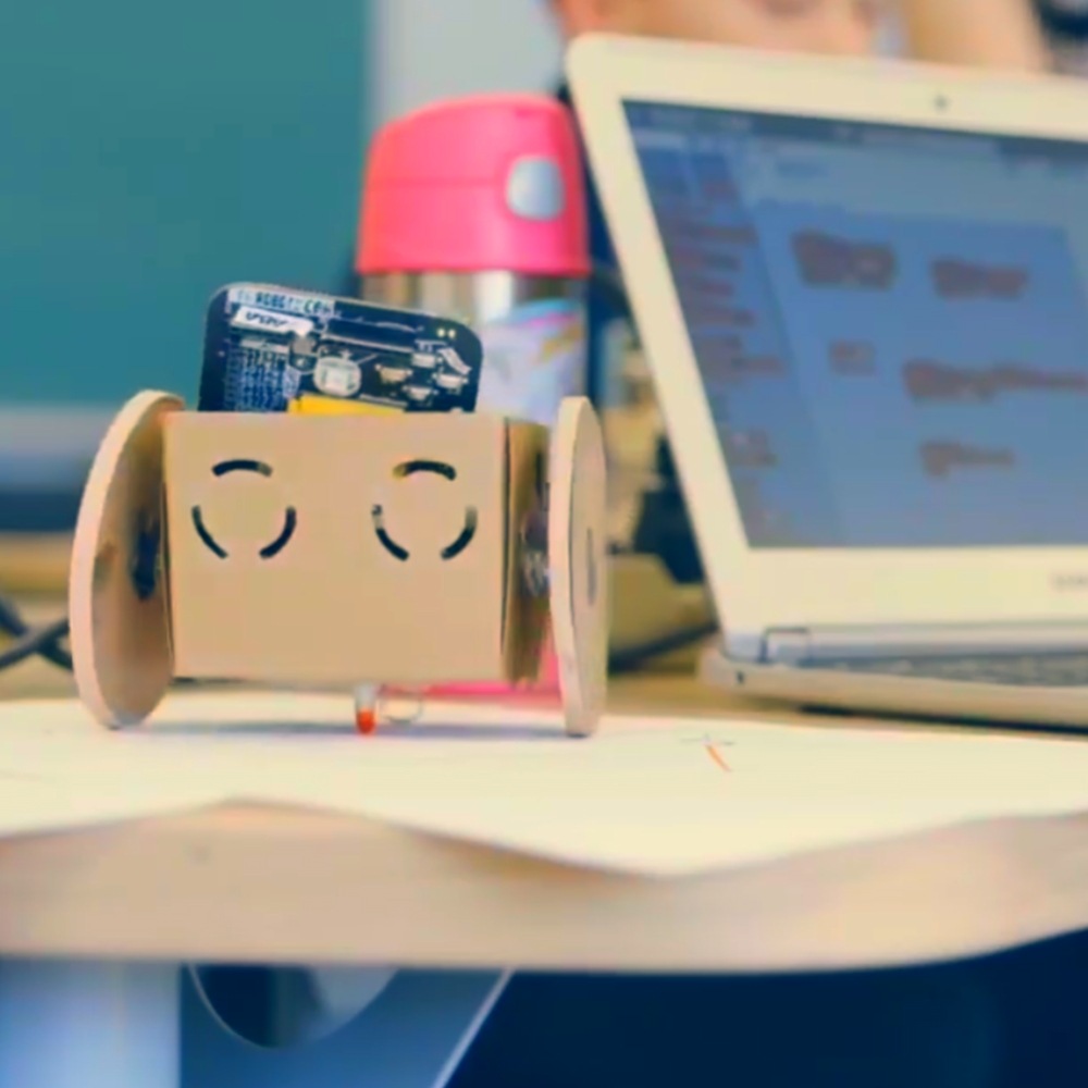 A Robot In A Can robot beside a laptop